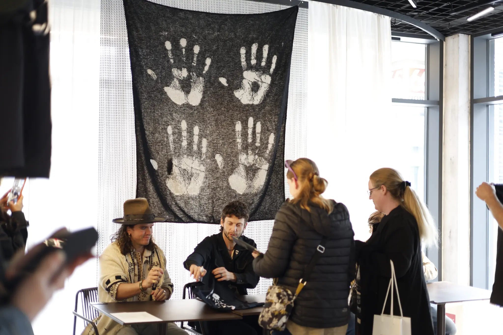 Kaleo album signing — the Varma handprints blanket as backdrop at the concert